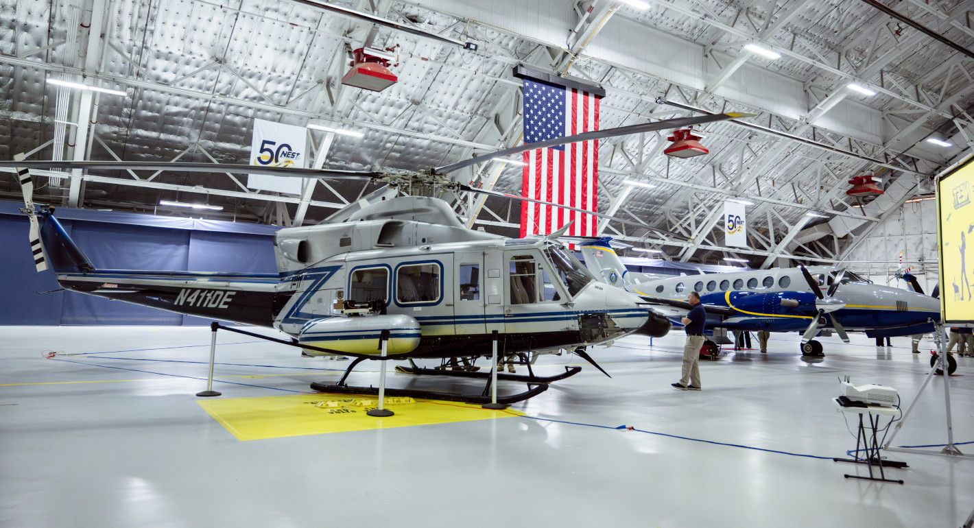 A plane and a helicopter in a hangar.