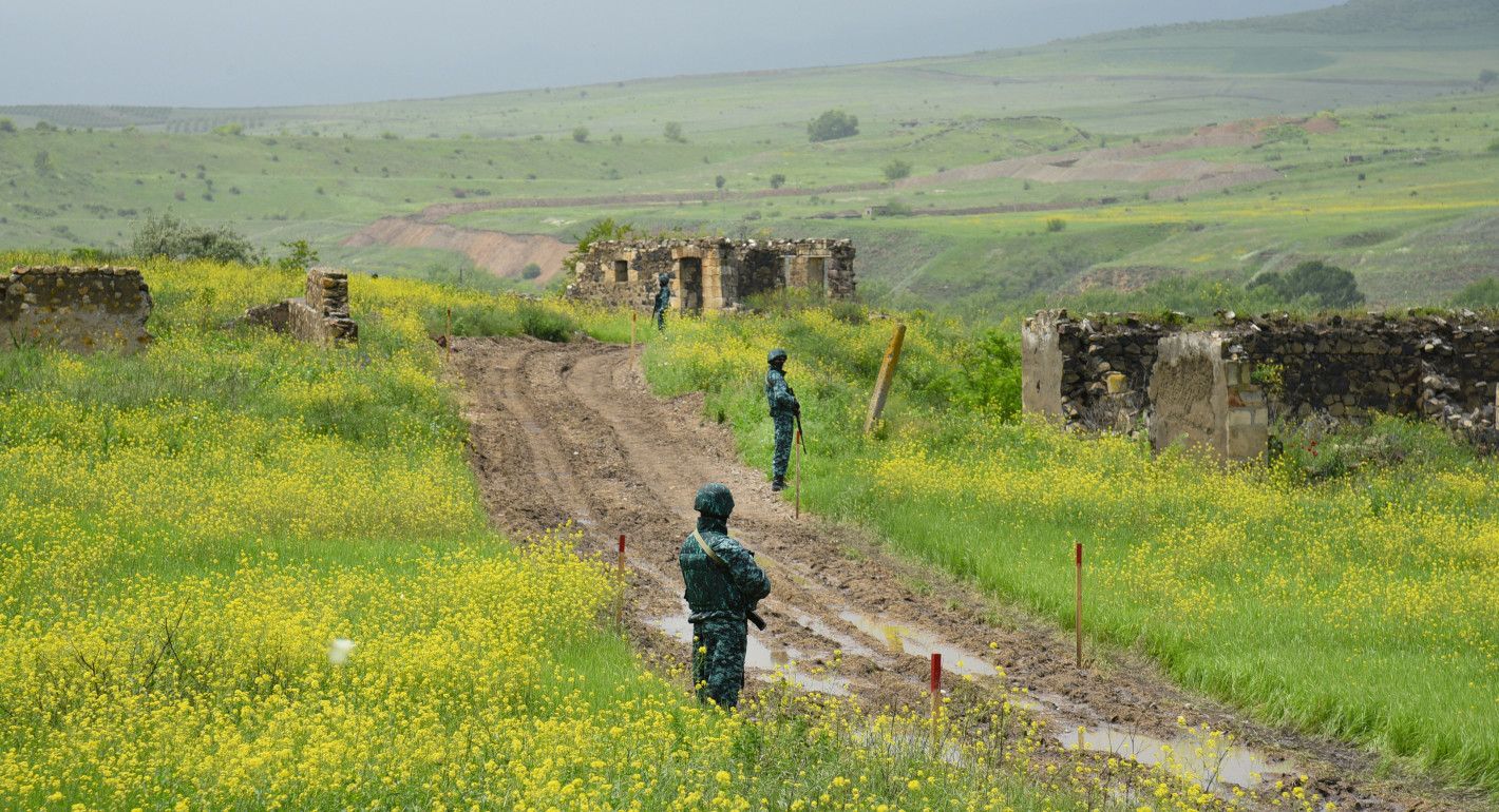 Soldiers patroling near abandoned stone buildings
