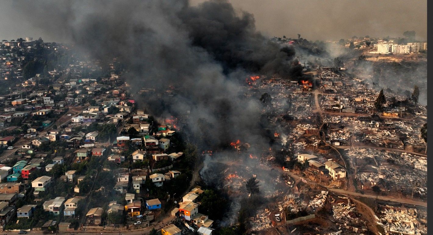 Aerial view of a wildfire destroying a neighborhood on a hillside