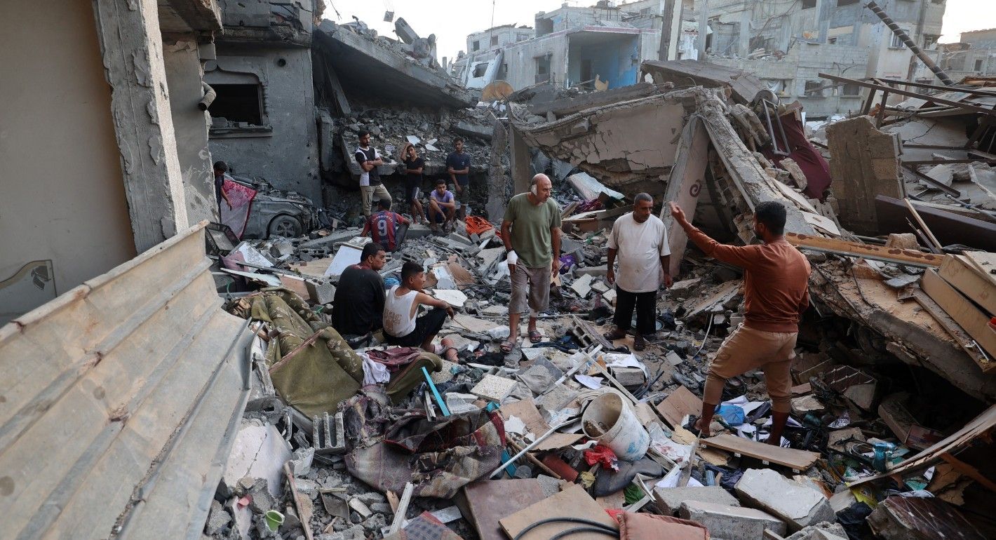 People standing in the rubble of a building