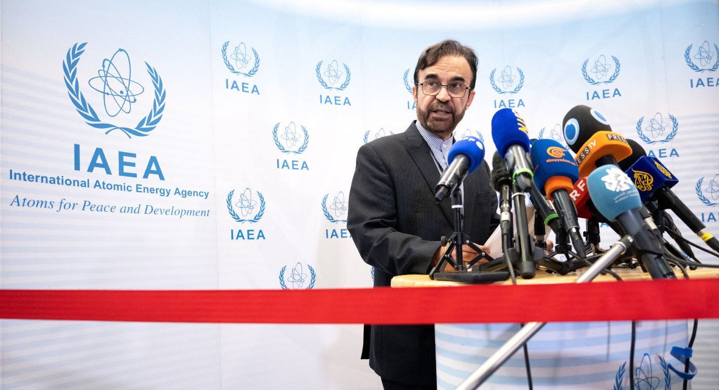 Man speaking into mics with an IAEA backdrop