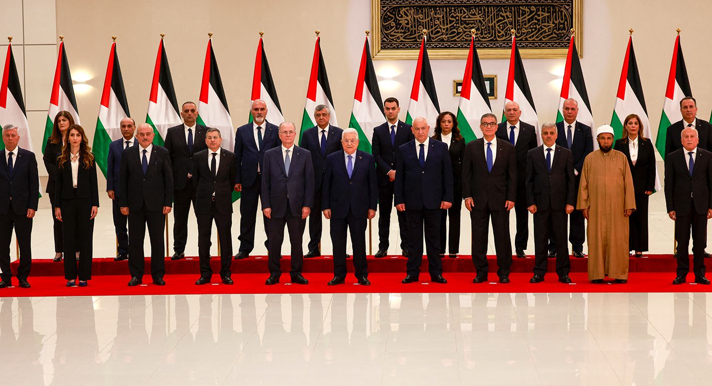 Palestinian Authority President Mahmud Abbas poses for a picture with new Palestinian government, after it was sworn in on March 31, 2024, in Ramallah, in the occupied West Bank. 