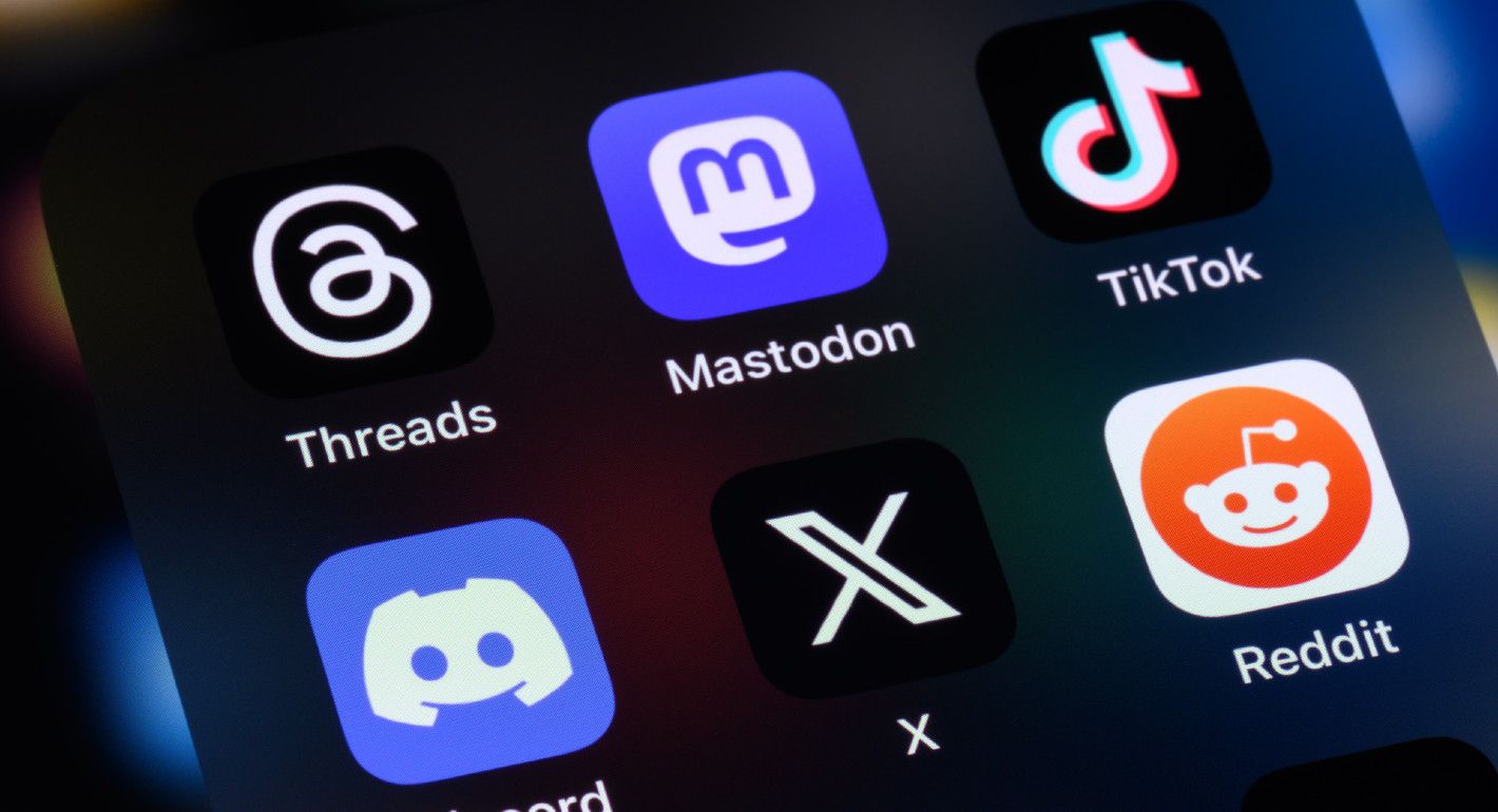 Photo of social media apps Threads, Mastodon, TikTok, Discord, X, and Reddit on a phone screen.