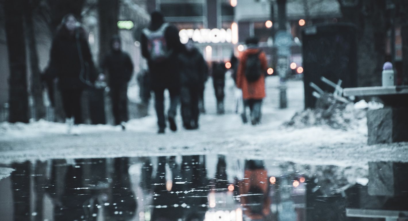 People walking on wet road during rainy season in Sweden