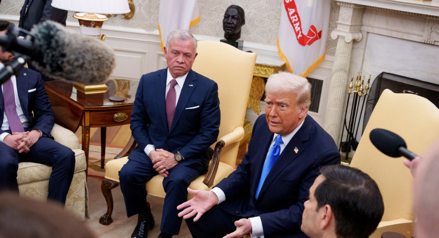 Trump and King Abdullah sitting in chairs next to each other, while Trump talks to reporters