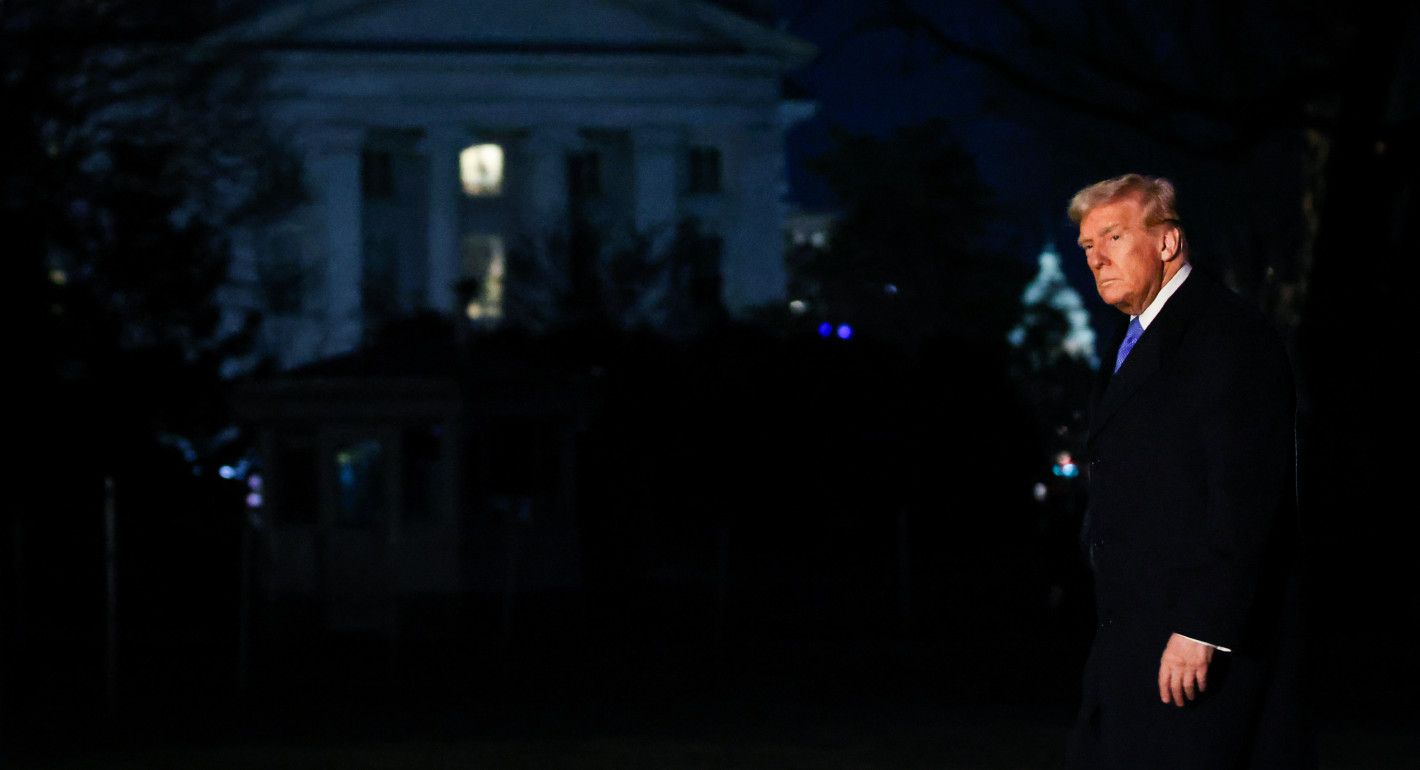 Trump walking in the dark, with the White House and the Capitol in the background