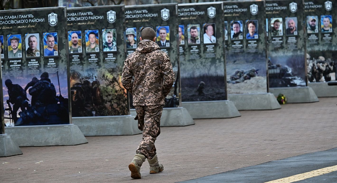 Ukrainian serviceman walks past portraits along the Alley of Fallen Heroes in a district of Kyiv on December 7, 2025, amid the Russian invasion in Ukraine